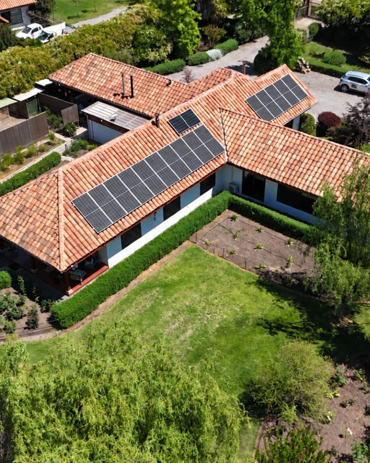 Vista aérea de una casa con paneles solares instalados en dos alas del techo