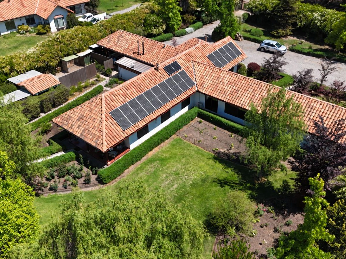 Vista aérea de una casa en L con paneles en dos alas del techo