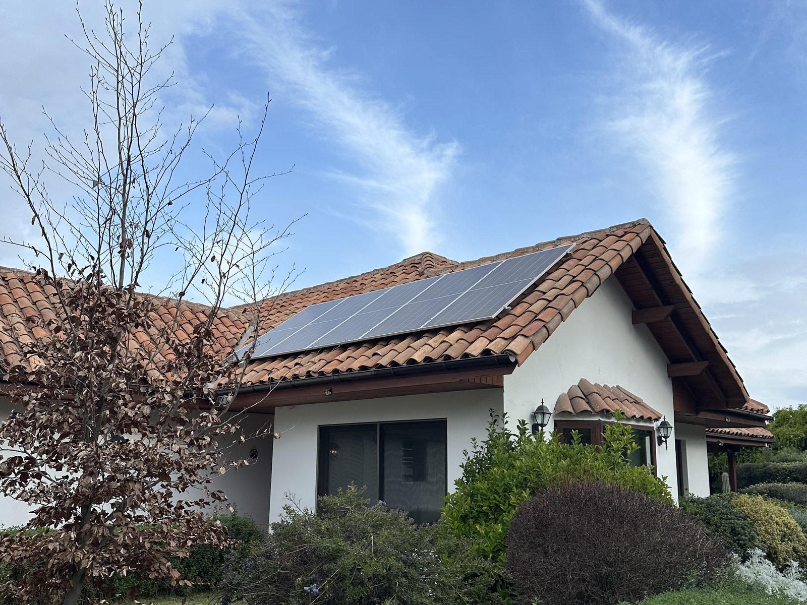 Fachada de la casa con los paneles solares en el techo