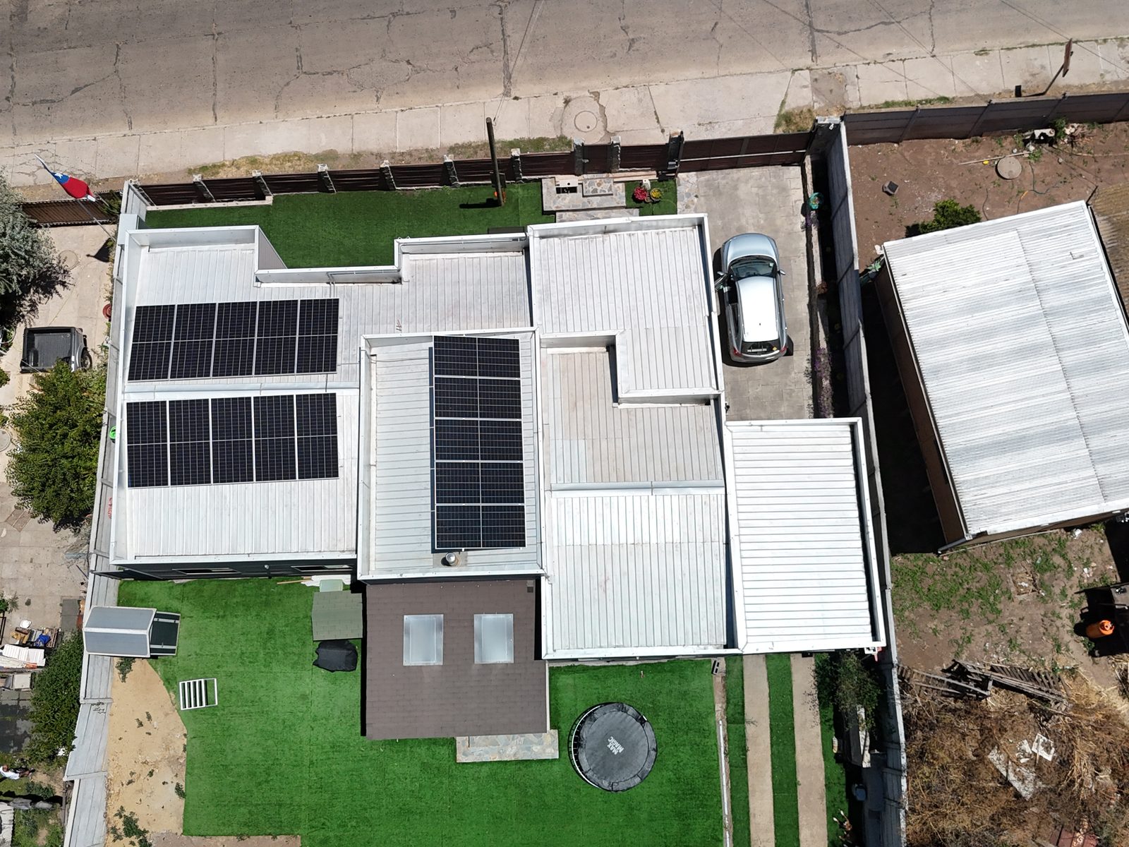 Vista aérea de una casa con paneles solares en el techo plano